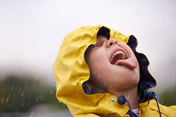 Image showing Girl child, headshot and rain for playing, shouting and happiness in nature, outdoor and winter. Female kid, raincoat or playful with water, open mouth or taste on adventure with freedom in childhood