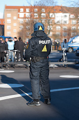 Image showing Safety, riot and rally with police officer in city for law enforcement, protection or security. Brave, uniform and government with person in street for protest demonstration, human rights or activist