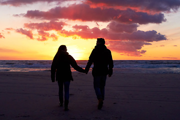 Image showing Beach, silhouette and couple holding hands at sunset while walking, bonding and enjoying freedom. Love, shadow and man with woman at the ocean for travel, romance and sunrise walk on Hawaii vacation