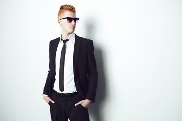 Image showing Fashion, suit and mockup with a man in studio on a white background for formal or contemporary style. Thinking, sunglasses and confident with a handsome young male person standing hands in pockets