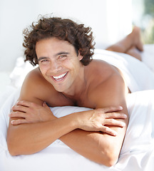 Image showing Portrait, happy and bedroom with a man lying on a bed in his home to relax or rest on a summer morning. Smile, wellness and lifestyle with an attractive young male person relaxing alone in his house