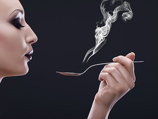 Image showing Makeup, hot and woman blowing a spoon with steam in studio with gothic, cool and danger aesthetic. Mockup, art and female posing with smoke and utensil creative, punk and edgy on black background