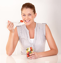 Image showing Woman, portrait and fruit salad in a studio with happiness from healthy breakfast and food. Smile, young female person and diet nutrition of a model with organic eating for wellness and health