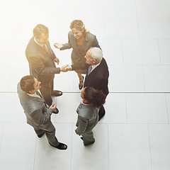 Image showing Top view, handshake and group of business people in meeting for deal, agreement or crm on mockup. Above, shaking hands and employees with b2b collaboration, partnership and welcome to company office.