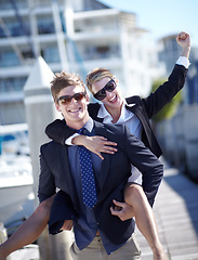 Image showing Piggyback, celebration and couple at harbor excited for success, startup and travel freedom. Business people, victory and cheerful man with woman before traveling in Amsterdam, winning and hand sign