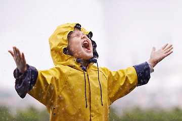 Image showing Girl, playing outdoor and screaming in rain, nature and excited with winter fashion. Female child, raincoat and playful with water, open hands and happiness on adventure with freedom in childhood