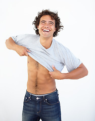 Image showing Happy, laughing and a man dressing in studio on a gray background while changing clothes for summer. Smile, funny or clothing with a handsome young male person getting ready in a jeans and t-shirt