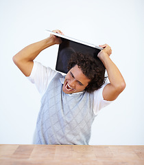 Image showing Angry, laptop and frustrated businessman smash his computer due to stress isolated in a white studio background. Anxiety, depression and male employee destroy equipment due to 404, glitch or error