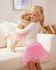 Image showing Golden retriever, hug and child happy together with love, care and development. Cute girl kid and animal puppy or pet in a tutu playing dress up as friends on the home sofa with happiness and trust