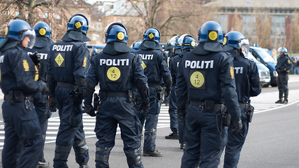 Image showing Law, security and back of police in city during a protest or march for protection and public service. Safety, violence and professional guards in uniform working in urban town street for peace patrol