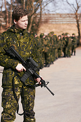 Image showing Army, military and soldier with a gun on a battlefield ready for war, fight or mission with courage and loyalty to a country. Hero, outdoor and man professional in service holding a rifle in gear