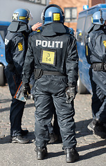 Image showing Safety, crowd control and protest with police officer in city for riot, protection or security. Brave, uniform and government with person in Denmark street for rally, human rights or activist