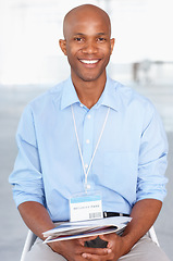 Image showing Business, portrait and young black businessman sitting in workshop and conference room at work. Convention, tradeshow and happy African male corporate worker with documents on lap in presentation