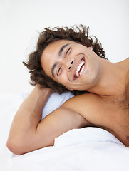 Image showing Face, laugh and a handsome man in bed in his home to relax or rest alone on a summer morning. Smile, wellness and lifestyle with a happy young male person relaxing in the bedroom of his house