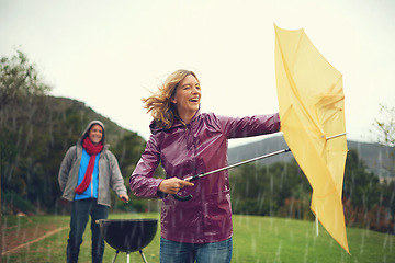 Image showing Man, woman and bbq in rain with umbrella, laugh or surprise weather with climate change in garden. Couple, outdoor and funny fail in storm, backyard or cooking in winter with run, wind or hurricane