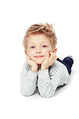 Image showing Portrait, smile and boy lying down, relax and cheerful kid isolated against white studio background. Face, male child or young person with happiness, casual and chilling with joy, happy and confident