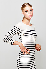 Image showing Woman, dress stripes and fashion portrait with designer style in a studio. Isolated, white background and young female model with confidence and stylish youth wearing cosmetics and luxury dress