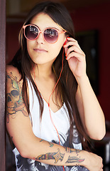 Image showing Tattoo, earphones and punk gen z woman with urban fashion or style relax while listening to music online. Podcast, radio and unique female person streaming audio or rock in summer with freedom