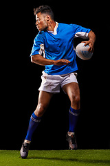 Image showing Rugby, night and man sports athlete running in dark studio background while training, wellness and fitness. Exercise, workout and professional career of sport male person or player on grass