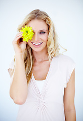 Image showing Beauty, happy and portrait of a woman with a flower in a studio with a cosmetic, natural and face routine. Makeup, smile and female model with a yellow floral plant isolated by a white background.