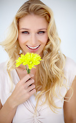 Image showing Portrait of happy woman, daisy and flowers in studio, isolated and white background. Female model smile with yellow plant, petals and fresh blossom for happiness, sustainability and floral beauty