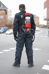 Image showing Emergency, police and man safety officer or fireman working a neighborhood street feeling fearless and ready for service. Security, legal and rearview of law enforcement person in a urban town