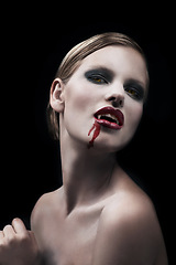 Image showing Portrait, woman and vampire with blood, lady and bare against a dark studio background. Face, female character and girl with fantasy, makeup and cosmetics with cosplay, person and supernatural being