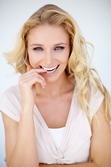 Image showing Flirt, portrait and woman biting her finger in a studio with a playful, shy and positive mindset. Happiness, smile and young beautiful female model with seductive pose isolated by a white background.