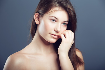 Image showing Face, beauty and portrait of a innocent woman in studio with a glow, makeup and cosmetics. Headshot of aesthetic female model on a grey background for natural shine, hair care and facial dermatology