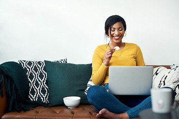 Image showing Sofa, laptop and woman eating chips for movie, video streaming service or subscription at home. Happy african person watch film with potato chip, computer and internet connection on living room couch