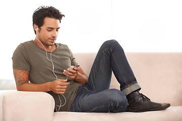 Image showing Relax, technology and a man with music on the sofa, streaming and calm in a house. Happy, home and a person on the living room couch listening to a podcast, audio or radio on digital tech online