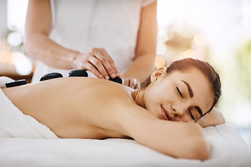 Image showing Relax, hot stone and woman getting a back massage at a spa for luxury, calm and natural self care. Beauty, body care and tranquil female person sleeping while doing a rock body treatment at a salon.