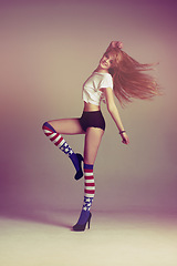 Image showing Portrait of woman with socks, fashion and energy in retro art style on studio background with American flag. Beauty, underwear and carefree, sexy influencer model jumping in vintage fun mockup space.