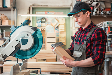 Image showing Carpenter worker cutting wooden board