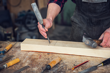 Image showing Carpenter working with a chisel