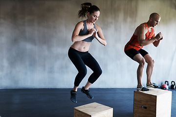 Image showing Gym, fitness and people on jump box for training, cardio or workout routine on wall background. Jumping, exercise and woman with personal trainer for endurance, challenge or leg strength performance