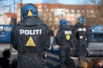 Image showing Safety, peace and crowd control with police officer in city for law enforcement, protection or security. Brave, uniform and riot with person in Denmark street for rally, human rights or activist