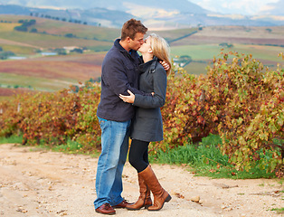 Image showing Love, romance and couple kissing in a vineyard outdoor while on a date in celebration of their relationship. Romantic, dating or kiss with a man and woman on a farm for agriculture or sustainability