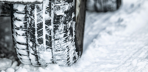 Image showing Tire, winter and car driving in snow or ice for a road trip, travel and outdoor journey using transport in cold weather. Ice, transportation and vehicle drive or traveling on a track in nature