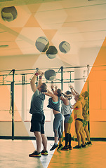 Image showing Fitness group, gym and people throw medicine ball for exercise, workout and training in class. Athlete men and women together for challenge, commitment and strong muscle at health club with overlay