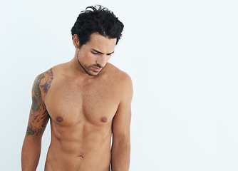 Image showing Shirtless, fitness and man standing and thinking isolated on a white background for health, wellness or body depression. Sad, training and thoughtful model or person with abs and tattoo in studio