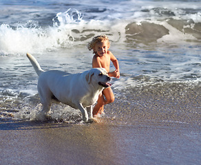 Image showing Child, dog and beach with kid playing with pet animal running on sand by the ocean. Holiday, children and dogs swimming by the water with happiness and smile of a toddler on vacation with pets