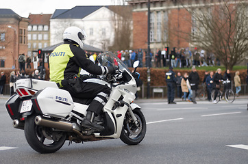 Image showing Emergency, motorbike and police or safety officer working for protection and peace in an urban town in Denmark. Security, law and legal professional or policeman on a motorcycle ready for service