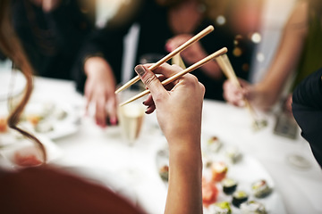 Image showing Chopstick, dinner party and woman hand at a restaurant at a table with drinks. Asian meal, sushi and friends celebration event with food and social group with drink together at a Japanese dining bar