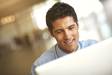 Image showing Computer, face and blurred background with a business man at work on a project in his office. Smile, internet and technology with a young male employee working on a desktop for a company report