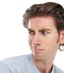 Image showing Young man, disgust and face looking over shoulder with anger, confused or frown against a white studio background. Isolated male model with annoyed, angry or funny facial expression and smirk