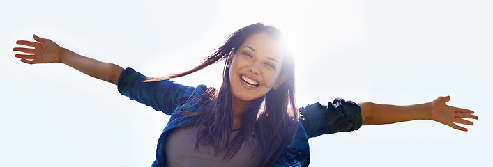 Image showing Portrait, sky and open arms with a woman outdoor in nature to celebrate a life of financial freedom in summer from below. Smile, banner and wellness with a happy young female person with lens flare