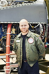 Image showing Portrait, pilot and military engine or male aircraft engineer in uniform and plane in hangar. Airplane, maintenance and officer gear or man mechanic in front aircraft for repairs or army and tarmac