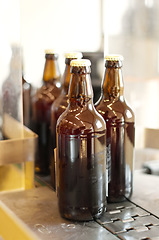 Image showing Production line, beer and bottles in factory, brewery or manufacturing plant. Alcohol glass, conveyor machine and automation of product in warehouse for industrial process in alcoholic industry.