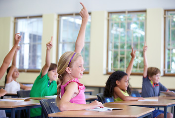 Image showing Children, classroom and raise hands on school desk or excited kids learning for test and future information. Education, knowledge and table for asking or exam answer or growth and child development